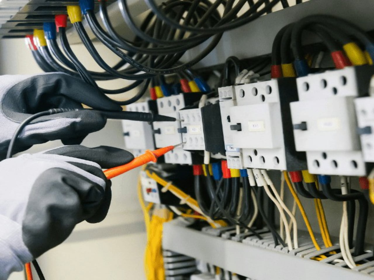Électricien contrôlant une armoire électrique au multimètre
