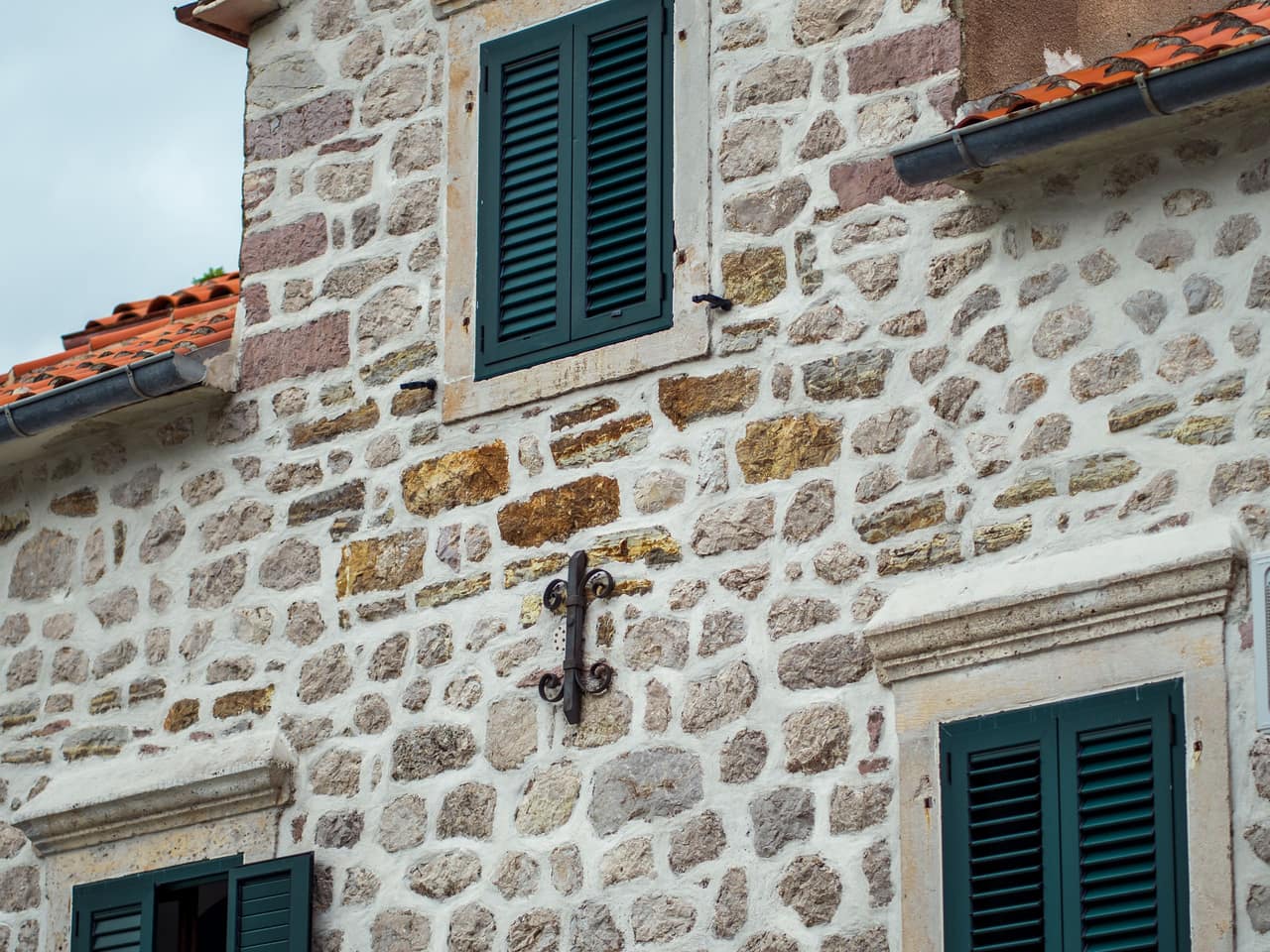 Façade en pierre appareillée aux joints nets, encadrements et volets soignés