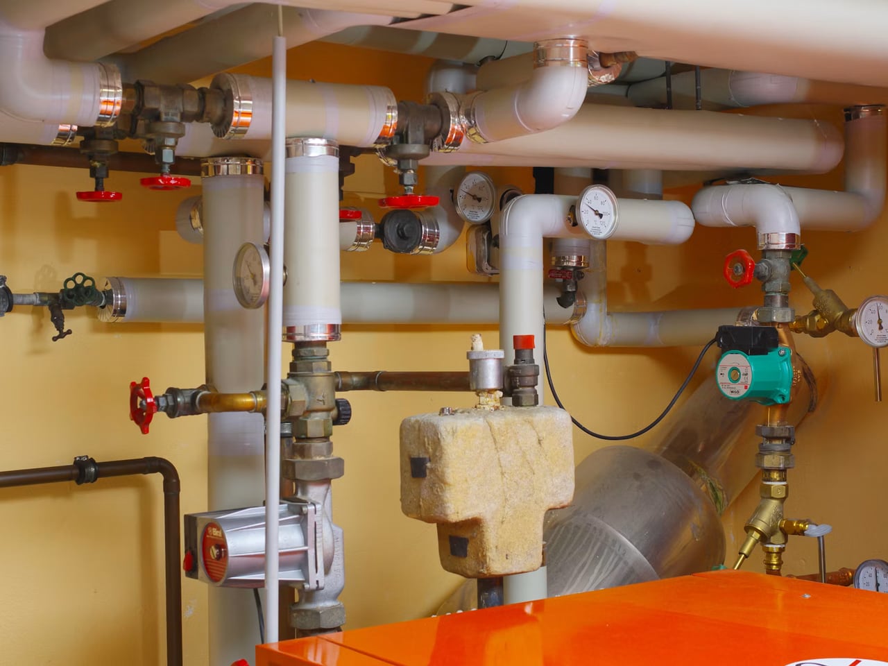 Installation de plomberie et chauffage soignée : tuyauterie, vannes et circulateur en chaufferie